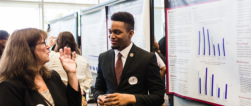 Student presenting a poster at a previous symposium