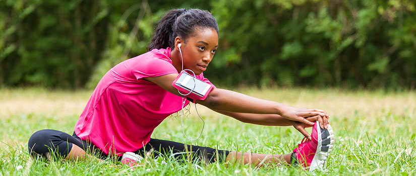 Woman stretching and listening to headphones