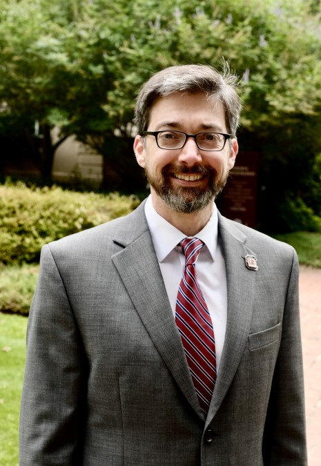 Portrait photo of Dr. Bonilha wearing a grey suit with a garnet tie, on the USC Horseshoe in Columbia, SC.