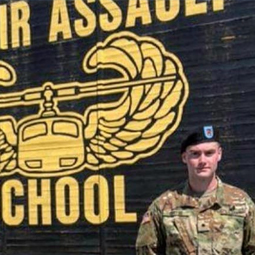 Cadet in front of air assault sign