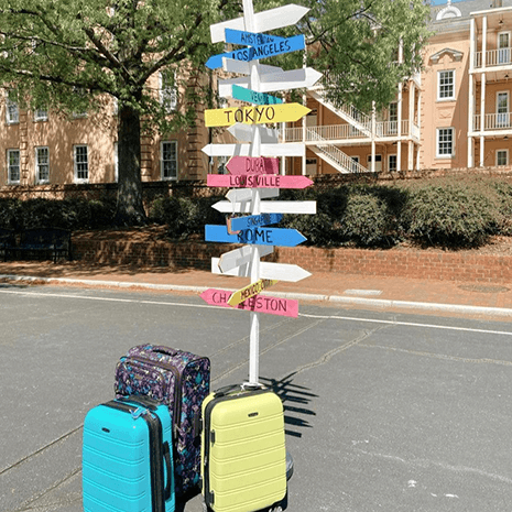 A stack of suitcases is seen with signs that name different interantional cities.