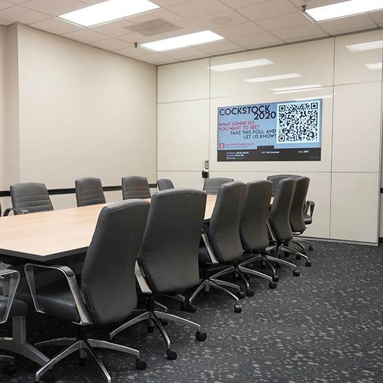 conference table with chairs and a board on the wall with paper to write on