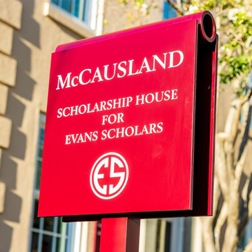 Red sign reading "McCausland Scholarship House for Evans Scholars."