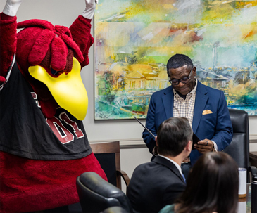 Cocky celebrates as VP Rex Tolliver learns about receiving an award