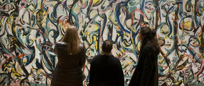three students looking at abstract artwork at local art museum 