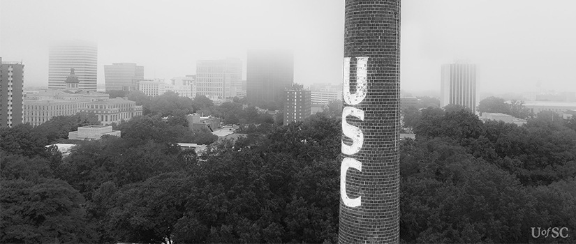 Black and white photo of the UofSC smokestack on a cloudy day in Columbia