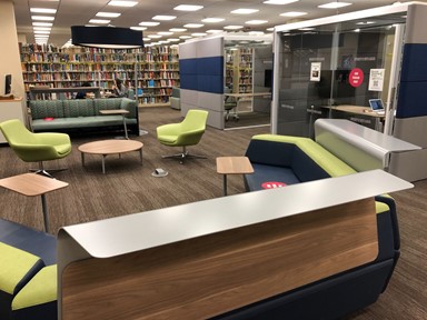 Photo of chairs, table and bookshelf on the first floor of Thomas Cooper Library 