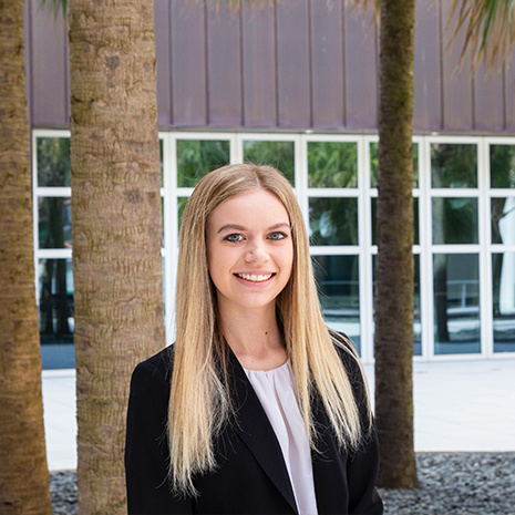 Photo of student sydney kelly in front of the Darla Moore School of Business 