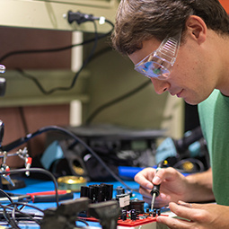 student with goggles working on a project
