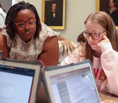 student and librarian looking at computer