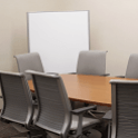 large rectangular table with 6 chairs and a white board