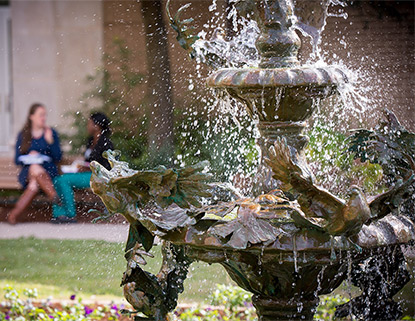 Water running off the fountain featuring doves in flight.