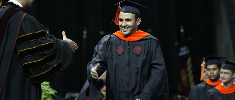 Graduate walks across stage to receive diploma
