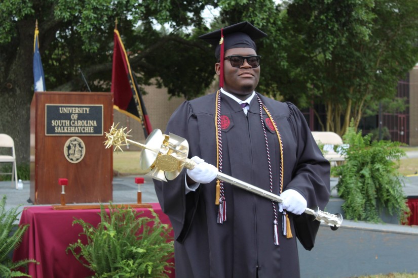 J-Dan Shaw Carries the mace at commencement.