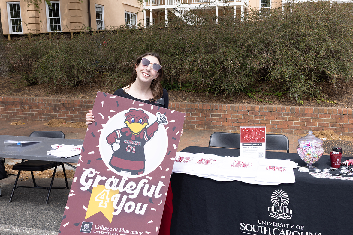 staff member holding grateful 4 you sign