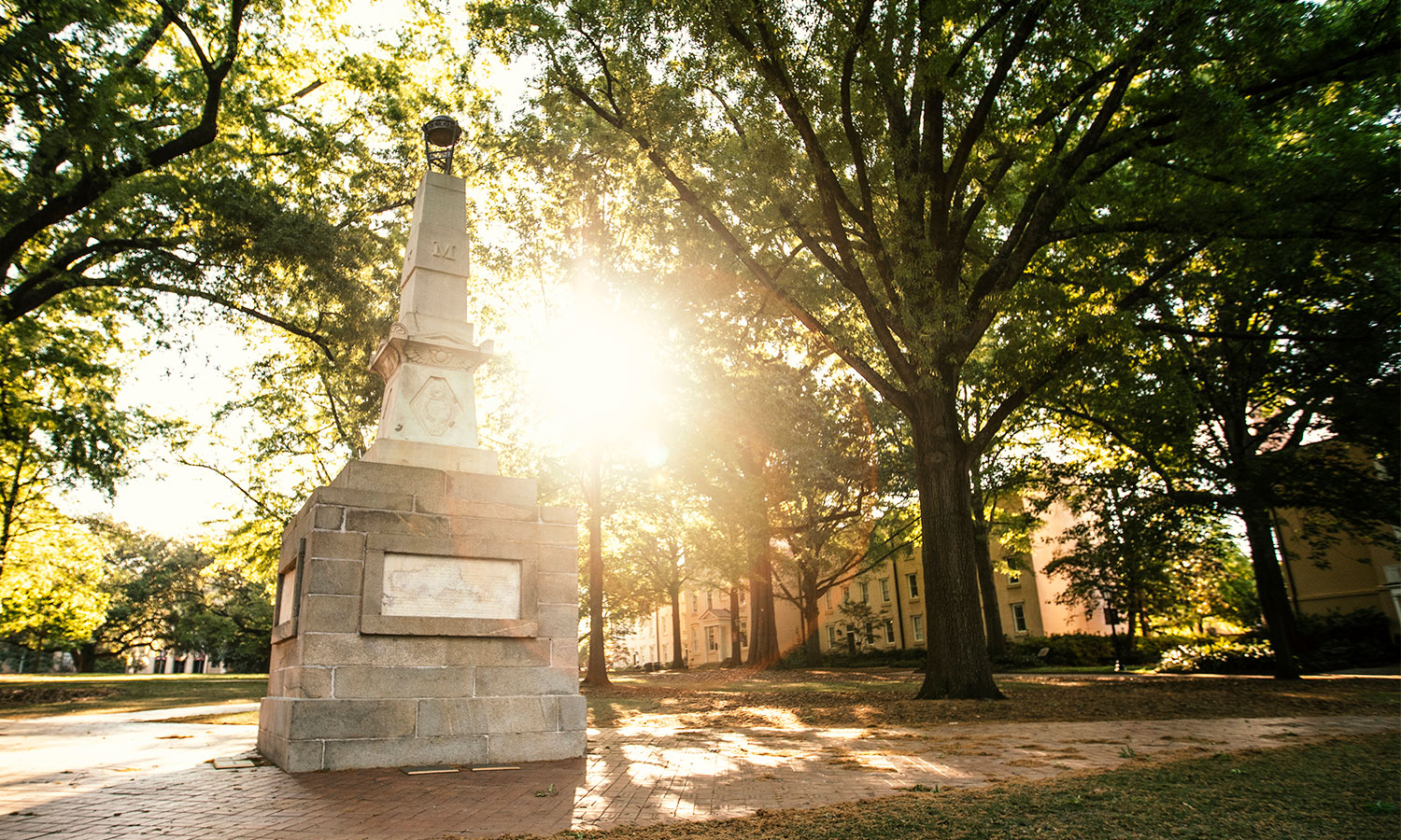 Maxcy Monument on the Historic Horseshoe with the sun shining through the trees.