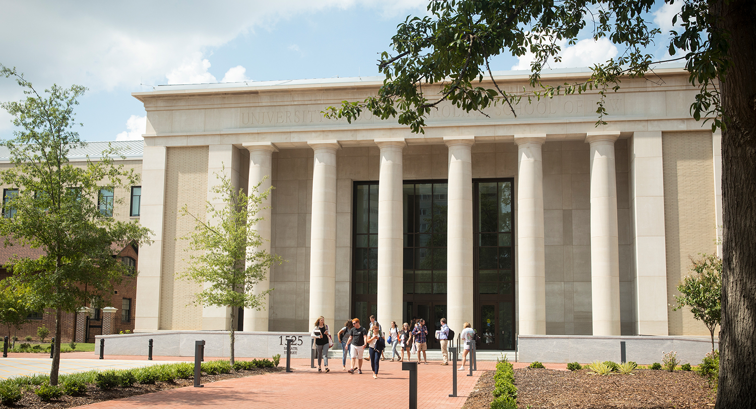 The School of Law building with a brick walkway and large columns across the front. 