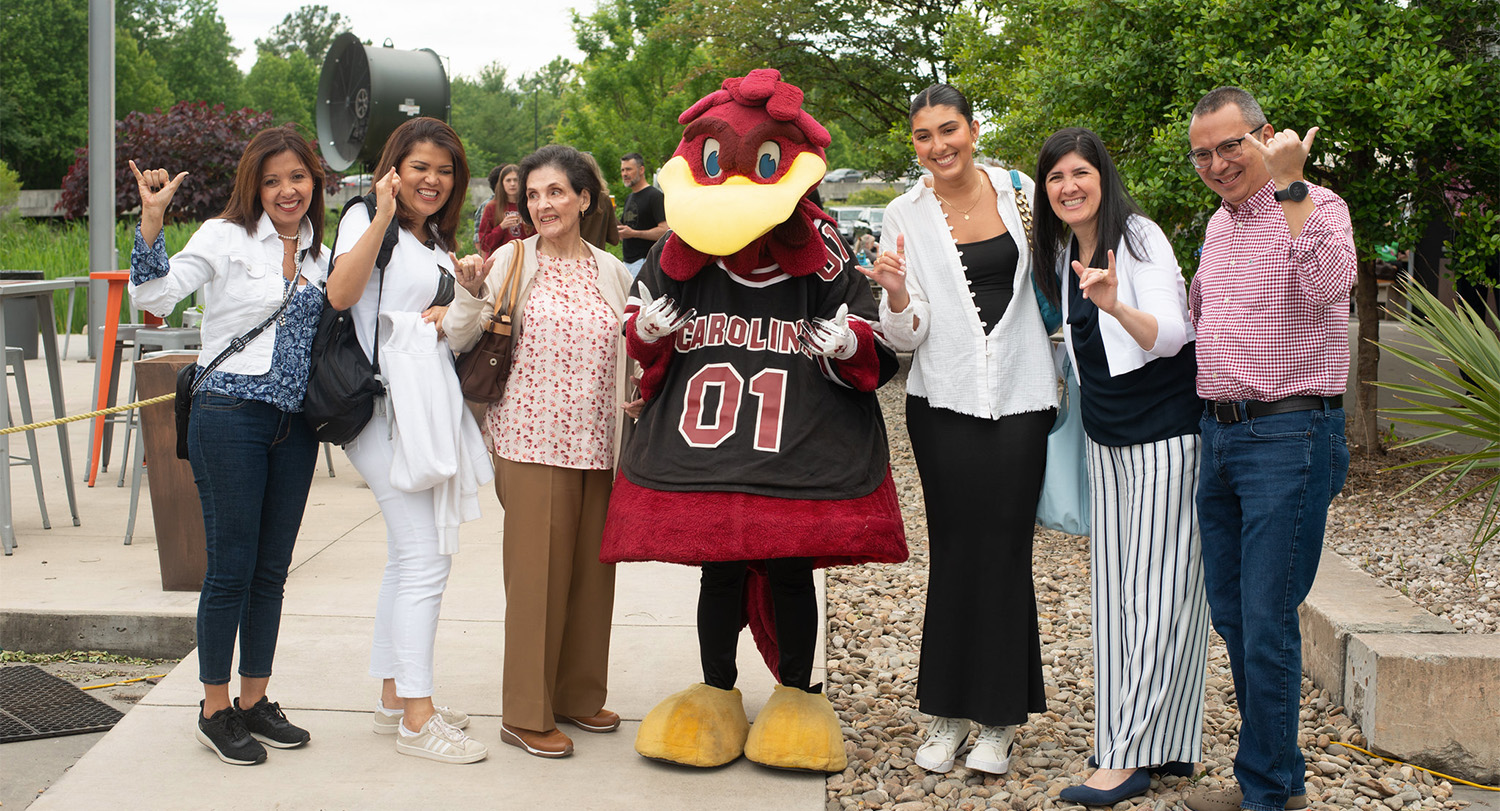 a family poses with Cocky outdoors at Grad Fest