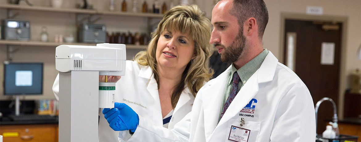 a pharmacy student working with a professor in the lab