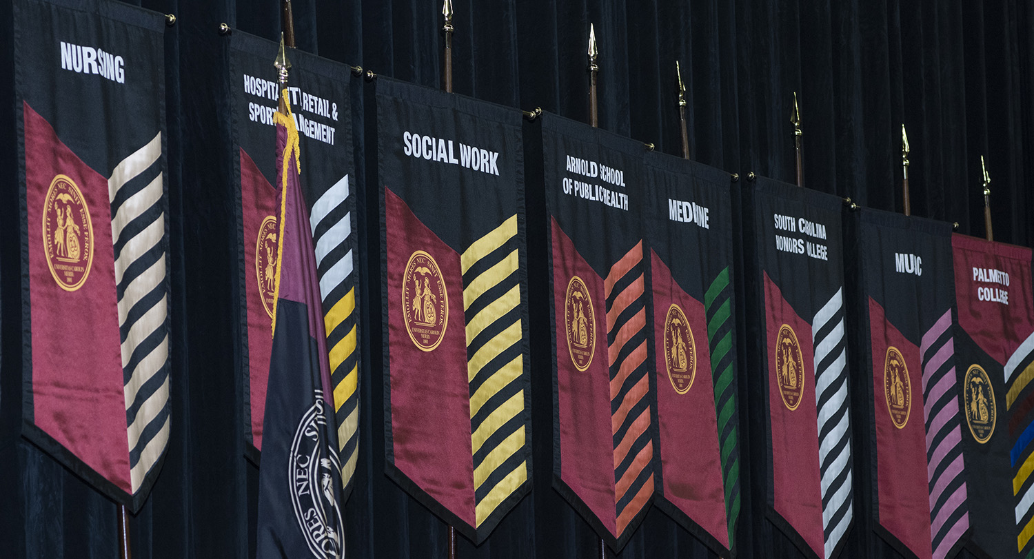 flags representing different university colleges on display at the convocation stage