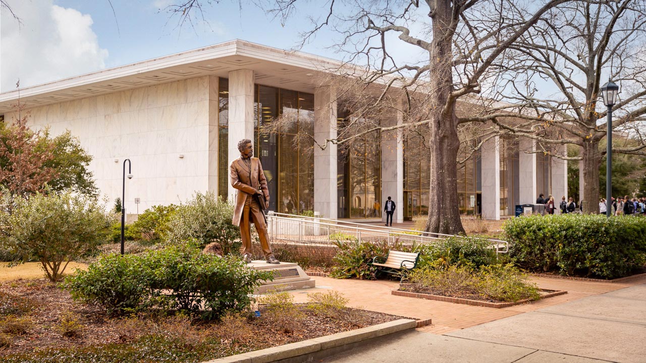 The bronze Richard T. Greener statue sits in front of the Thomas Cooper Library. 