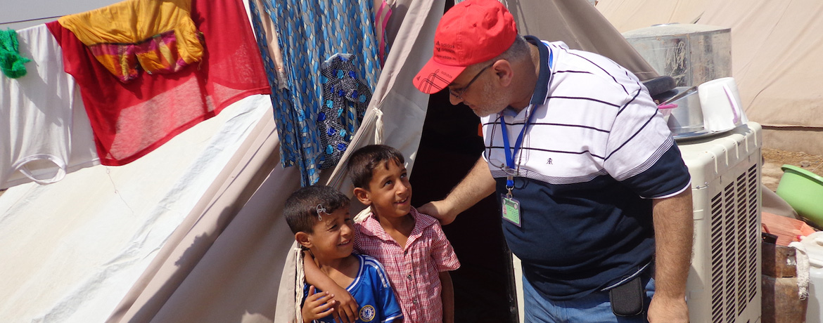 professor talking to two young children at a shelter
