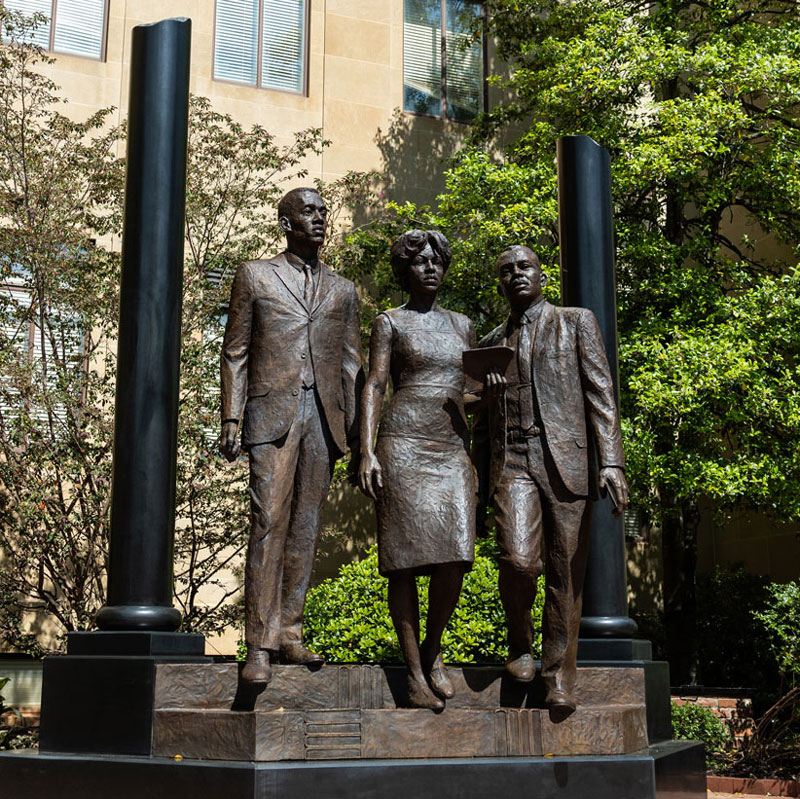 Mckissick Museum with garnet banners on between the large stone columns surrounded by trees on the historic Horseshoe. 