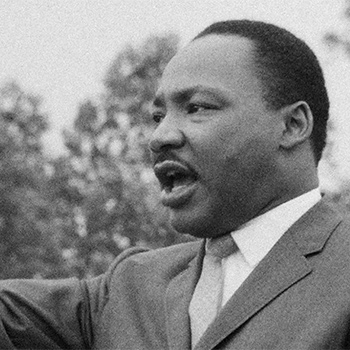 Historical image of Martin Luther King Jr. speaking at an event.