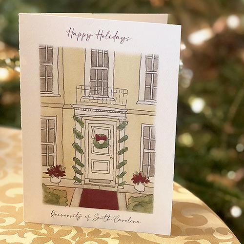 The USC 2022 holiday card with an illustration of the President's House frond door sitting on a table. 
