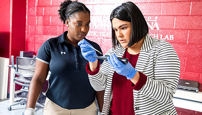 Two students preforming a test in the athletic training lab 
