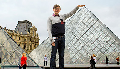 Person posing outside the Louvre Museum.