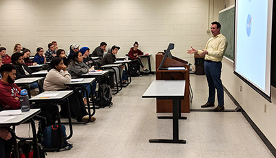Professor teaching in front of a classroom full of students.