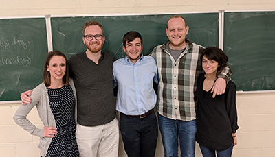 A group of students in front of a chalkboard.