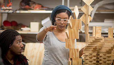 Art student working on a wooden sculpture.