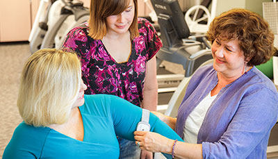Two people working with a patient in a physical therapy setting. 