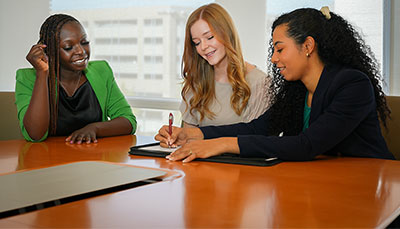 Three young business professionals having a meeting at a conference room table. 