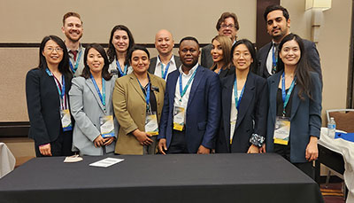 Group of graduate students posed together at a conference.