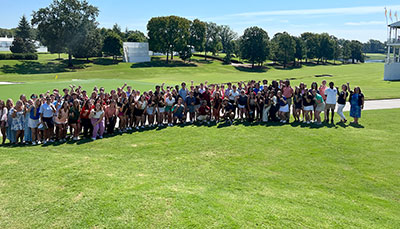 Large group of people on a golf course. 