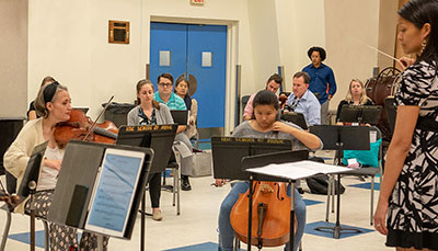 Graduate student conducting the band in a music class.