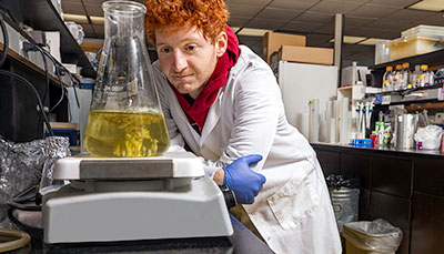 Researcher in a lab watching a beaker. 