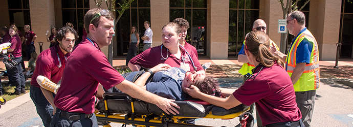Medical student pushing a stretcher with a patient.
