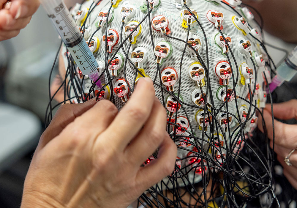 Brain research showing wires connected to a cap on a participant's head.