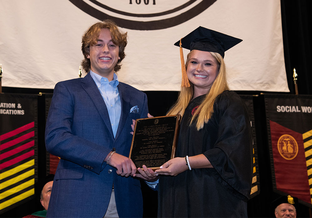 A student receives the Creed award from the student body president.