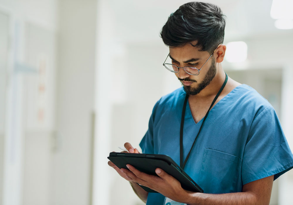 A nursing student using a tablet device in a clinical setting