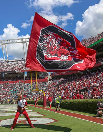 Huge Gamecock flag being waved in the end zone at the Williams-Brice Stadium.