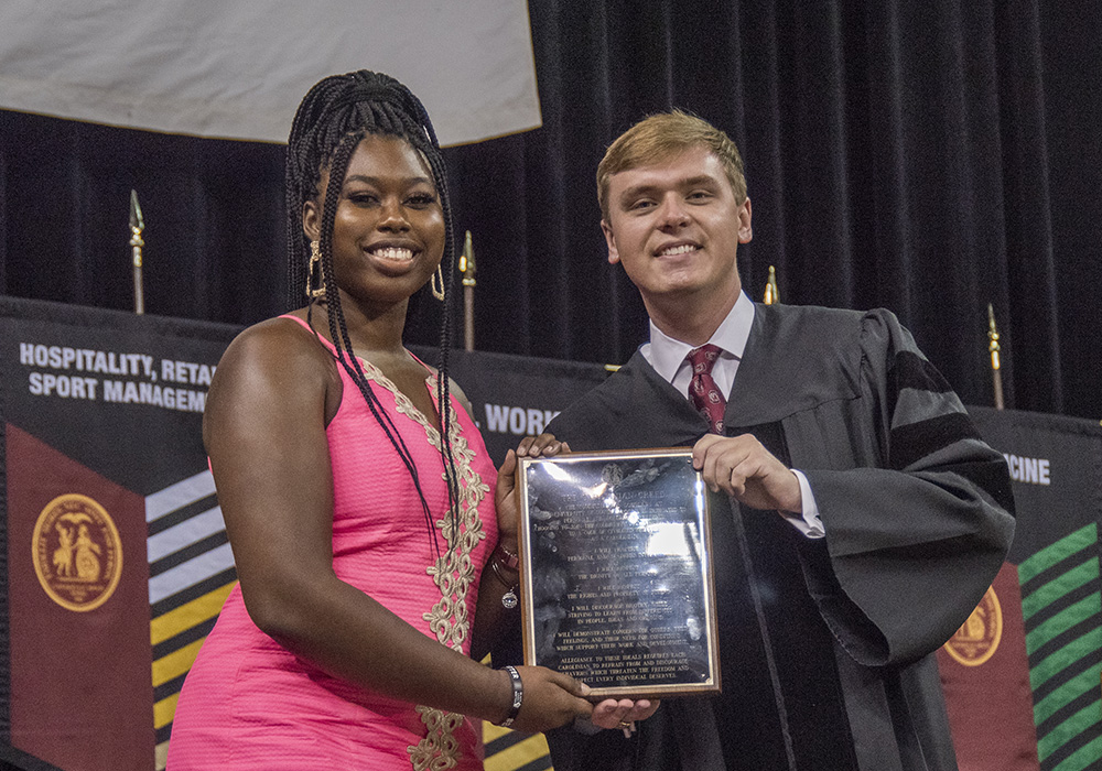 a student receives the Creed award from the student body president