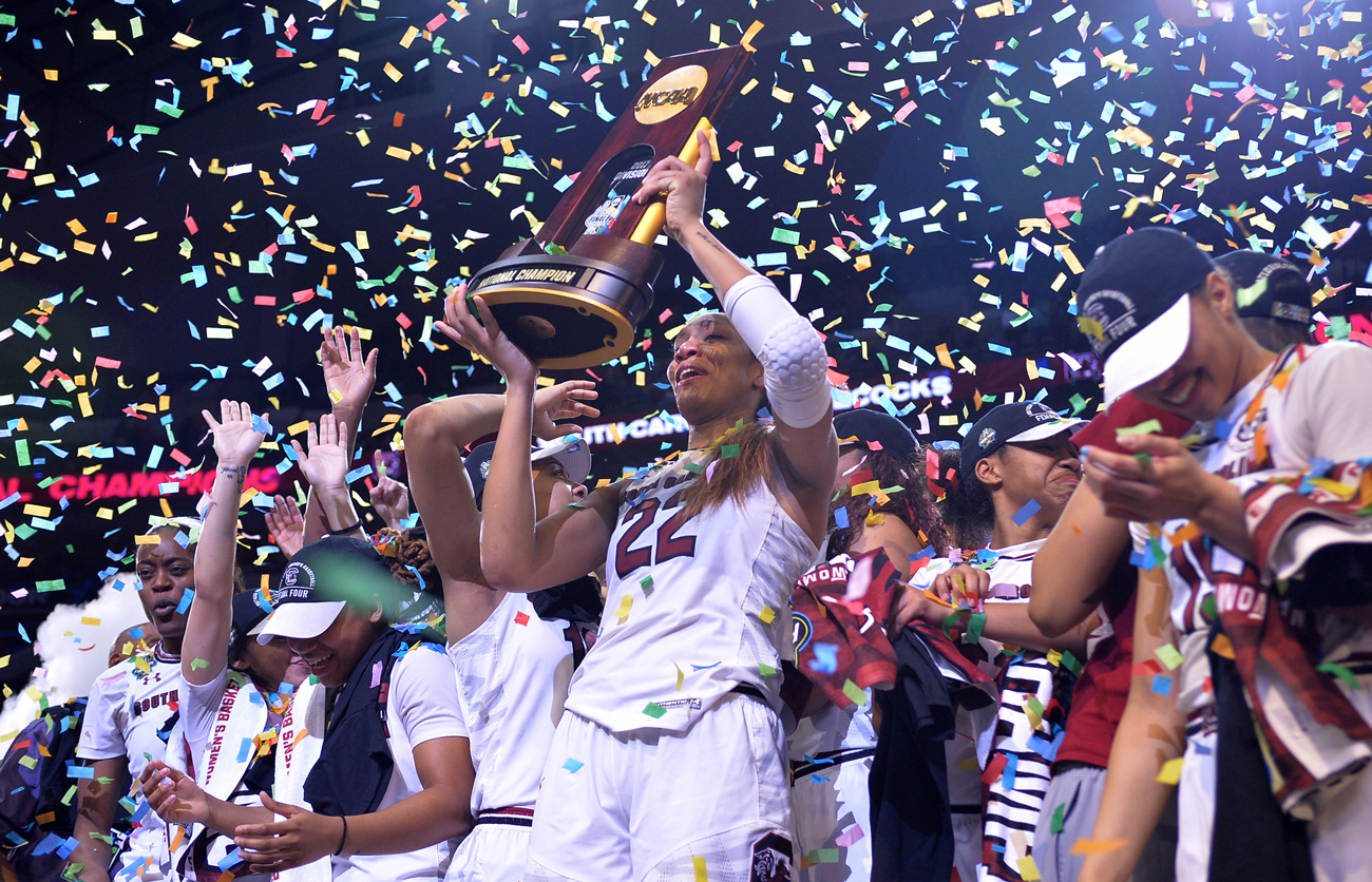 A'ja Wilson lifts the national championship trophy as her teammates celebrate and confetti falls