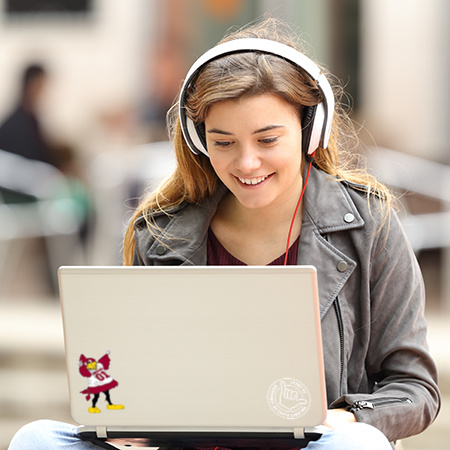 Student with headphones on using a laptop