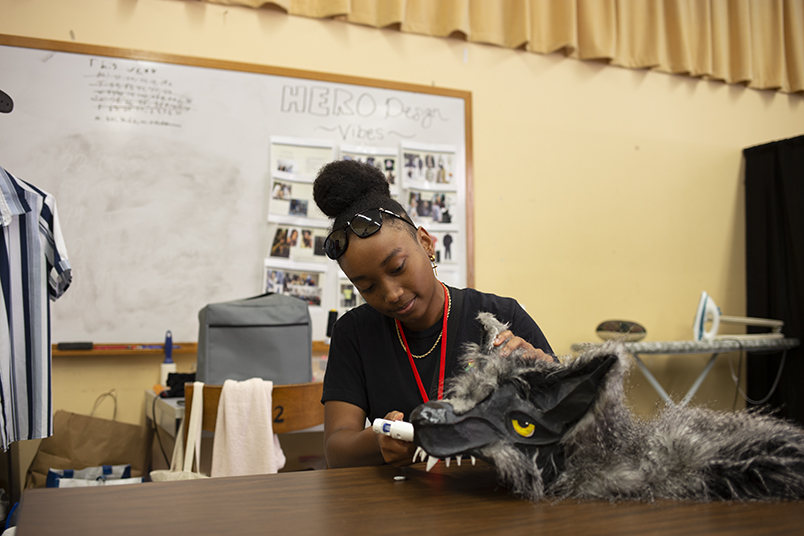A student works on repairing a wolf costume.