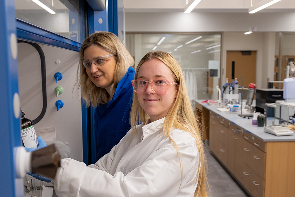 Natalia Shustova and Katie McBride work under the hood in the chemistry lab.